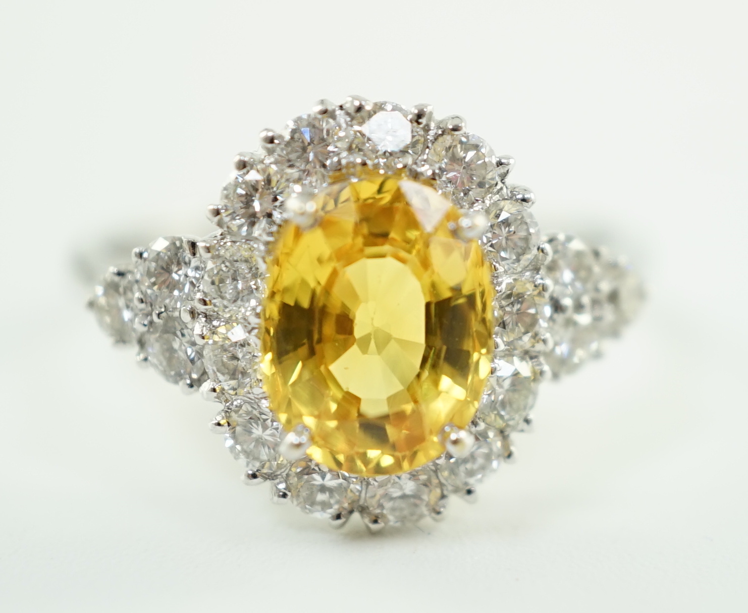 A modern 18ct white gold and single oval cut yellow sapphire set ring